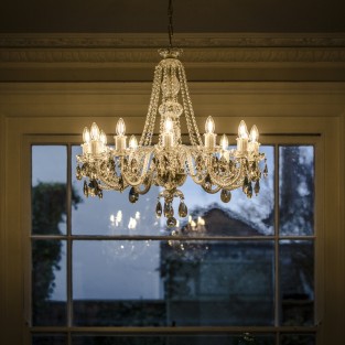 This graceful arm chandelier features rope twist glass arms, glass candle holders and glass cups