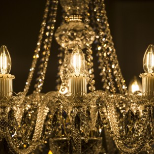 This graceful arm chandelier features rope twist glass arms, glass candle holders and glass cups